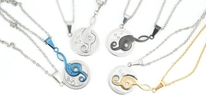 Detailed macro view of musical treble clef couple necklaces in four polished steel finishes