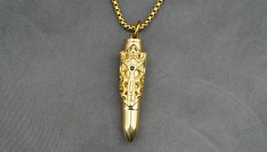 Macro detail of golden bullet pendant necklace with gothic relief and black diamond inlay