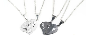 Close-up of interlocking heart and key couple necklaces with Love You engraving in steel