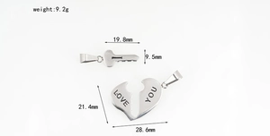 Detailed view of polished stainless steel heart and key pendants with Love You engraving