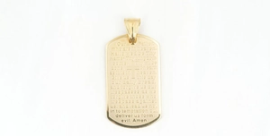 Macro view of gold dog tag pendant with engraved Lord's Prayer and central cross