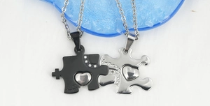 Dettaglio dei ciondoli a puzzle a cuore con incisione Just For You e piccoli strass