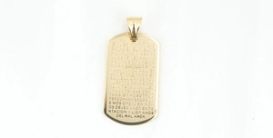 Macro detail of gold cross pendant featuring engraved Spanish Lord's Prayer text
