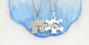 Dettaglio macro delle collane puzzle a cuore per coppia con incisione Just For You