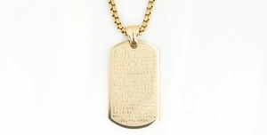 Detail of gold titanium steel cross pendant with engraved Spanish Lord's Prayer text