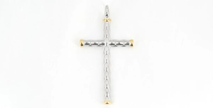 Vue détaillée du pendentif croix bicolore avec touches dorées et texture géométrique