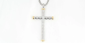 Gros plan d'un pendentif croix argenté avec touches dorées et motif diamanté