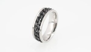 Detailed macro view of rotatable black cuban chain inlay on silver titanium steel ring