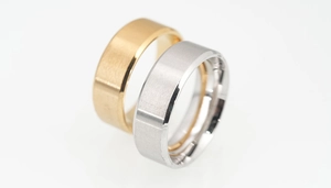 Macro shot of matte brushed gold and silver titanium steel rings with polished edges