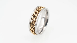 Close-up of rotatable golden chain inlay on a polished silver spinner ring band