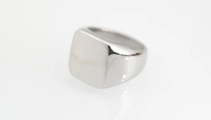 Gros plan sur une bague chevalière carrée en argent poli avec une finition miroir