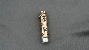 Détail du pendentif urne cylindrique doré avec motif patte noire et capuchon argenté