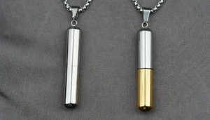Detalle macro de los collares con colgante de cápsula en acero plata y bicolor oro plata