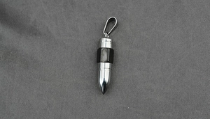 Detailed macro view of the silver and black bullet-shaped stainless steel pendant