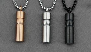 Macro shot of minimalist stainless steel cylindrical pendants in rose gold, steel and black