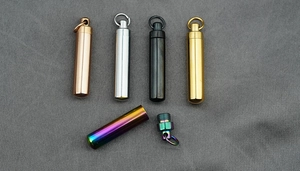 Detail of waterproof titanium steel capsule pendant with secure screw cap and metal loop