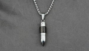 Detailed macro view of the silver and black steel bullet pendant and box chain necklace