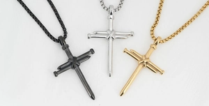 Detailed view of industrial cross necklaces in black, silver, and gold polished finishes