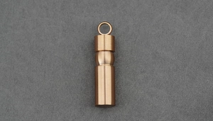 Detailed macro view of the brushed rose gold titanium cylindrical pendant urn with screw cap