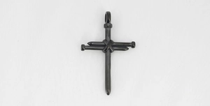 Detail of cross pendant made of black steel nails with wire wrap industrial design