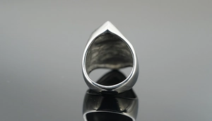 Macro shot of mirror-polished silver punk skull ring with geometric heavy metal band details