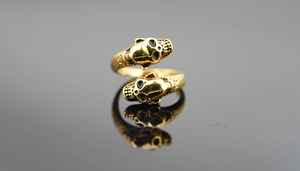 Macro shot of gold punk skull ring with scale texture and open adjustable band