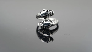 Close-up of gothic double skull open ring with vintage silver finish and scale texture