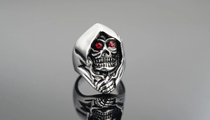 Detailed macro view of a silver gothic skull ring with striking red rhinestone eyes
