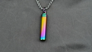 Macro detail of rainbow oil-slick titanium steel urn pendant with square link chain