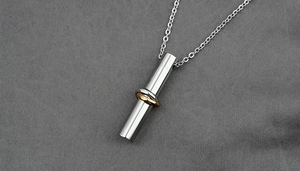 Detailed close-up of cylindrical cylinder urn pendant with interlocking rose gold rings