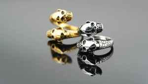 Macro view of gold and silver skull rings featuring detailed snake scale textures