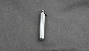 Macro shot of silver stainless steel cylinder necklace pendant with secure screw top