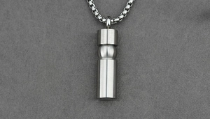 Detail of cylindrical titanium steel necklace with brushed metal finish on box chain