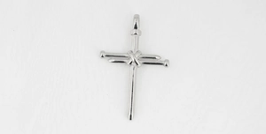 Macro detail of polished stainless steel nail cross pendant with wire wrap design