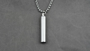 Detail view of cylinder pendant necklace with polished stainless steel and box chain