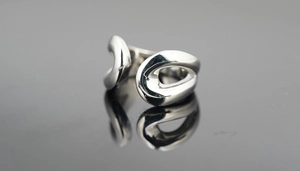 Vue détaillée d'une bague en argent poli au design ondulé et entrelacé élégant