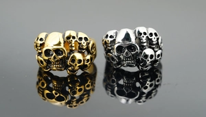 Détail de bagues crâne vintage en or et argent avec des reliefs de style punk gothique