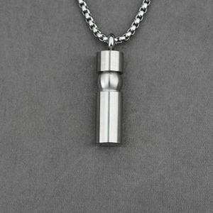 Men's titanium steel cylindrical capsule pendant necklace with silver box chain on grey fabric