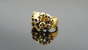 Vue macro de crânes empilés style punk sur une bague pour homme en acier doré