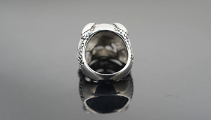 Macro-opname van zilveren schedelring met schubtextuur en vintage geoxideerde details