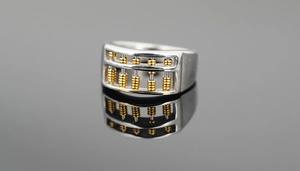 Detail of a rotating golden bead abacus ring in polished silver stainless steel
