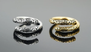Macro detail of retro golden and silver spiral rings featuring intricate embossed patterns