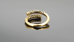 Macro shot of golden Monkey King staff ring featuring vintage cloud patterns and textures