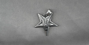 Detailed view of vintage silver pentagram pendant with carved Baphomet goat head motif