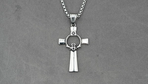 Detail of silver Claddagh cross pendant with polished box chain on gray fabric background