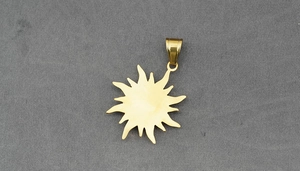 Detailed macro of a vintage 316L stainless steel sunflower pendant in gold finish
