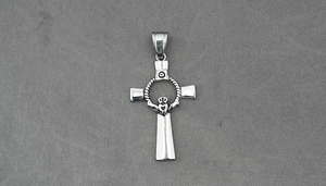 Macro shot of vintage silver cross pendant with Claddagh heart and crown detailing