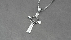 Detailed macro view of silver Claddagh cross pendant with a polished box chain necklace