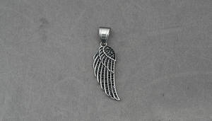 Detailed macro view of retro black diamond encrusted feather pendant with wing texture