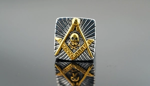 Detailed macro view of the silver and gold Freemasonry ring with skull emblem